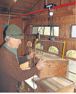 Der bayerische Imker an seiner selbstgebauten Hebevorrichtung für Bienenkästen.