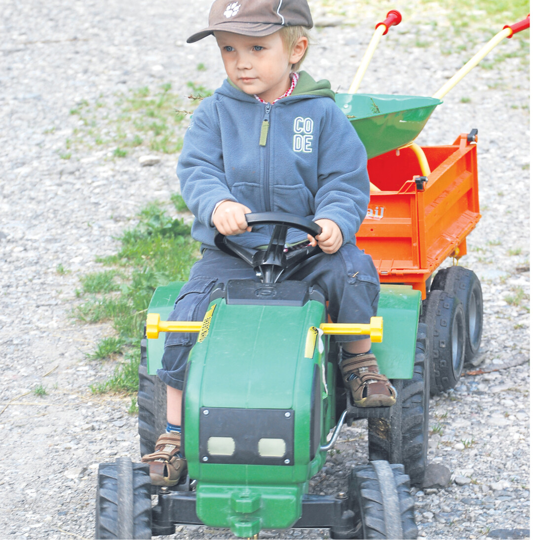 Auf einem Bauernhof erleben Kinder, was an Arbeit anfällt. Im unbeschwerten Spiel vollziehen sie das nach. Und Schlepperfahren macht immer Spaß, auf kleinen oder großen Modellen. Man sieht es Malte an.