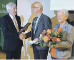 Landesvorsitzender Hubert Hopp überreicht das Goldene Verbandsabzeichen an Paul Wiker und Blumen an dessen Frau Waltraud.