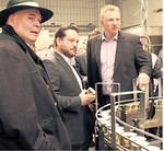 Vor dem Laufband der Wurstdosen mit wiederverschließbarem Schnappverschluss, v. l.: Rudolf Bühler, Agrarminister Alexander Bonde und der Technische Leiter Steffen Noller.