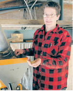 Alexander Thumm vor der Ölpresse, die direkt unter dem Toaster angebracht ist.