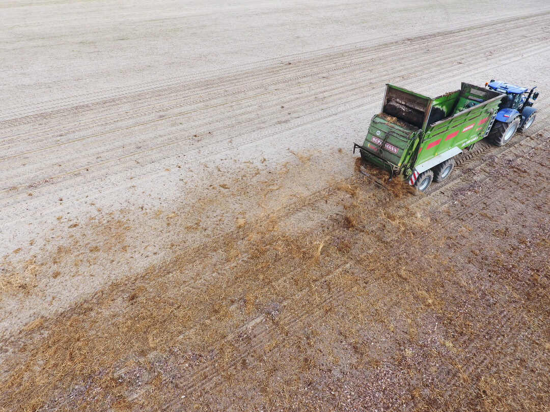 Mist streuen mit New Holland Schlepper und Bergmann-Streuer.