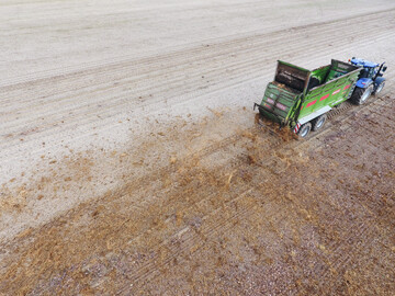 Mist streuen mit New Holland Schlepper und Bergmann-Streuer.