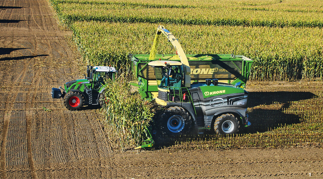 Standardgespann bei der Maisernte auf dem Acker und auf der Strae: ein leistungsstarker Traktor mit Hckseltransportwagen.