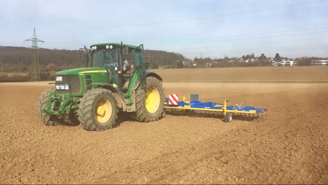 Gleich nach der Aussaat fährt Volker Escher mit dem Striegel über das Feld.