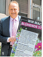 Joachim Rukwied stellt das Aktionsschild Blühstreifen" vor.