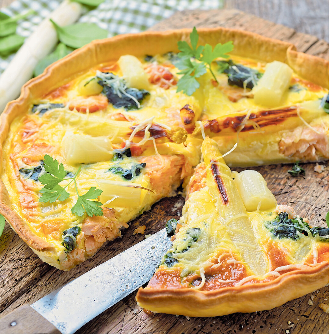 Die passt jetzt beim Gartenfest zu einem Glas Weißwein oder einem würzigen Bier: Eine leckere Tarte mit weißem Spargel, Spinat und Räucherlachs.