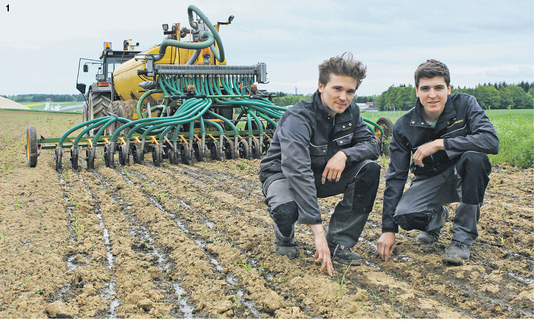 Christopher (l.) und Stephen Häußler sind mit dem Arbeitsergebnis ihres selbstgebauten Schlitzgerätes sehr zufrieden. Gut zu erkennen ist die nachgerüstete Fliegl-Schnecke, die den Güllestrom auf die Zuleitungen verteilt.