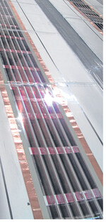 Ausschnitt der fertigen organischen Solarmodule (rötliche Streifen) auf der Membranfolie (weiß).