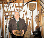 Museums-Chef Sepp Schelshorn mit Erntegeräten und einem Moor-Schuh für Pferde.