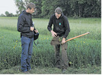 Landwirt Adrian Schmid (l.) und Bioland-Berater Jonathan Kern zeigen anhand der Spatenprobe im Linsen-Hafer-Gemenge einen garen Boden mit guter Durchwurzelung.