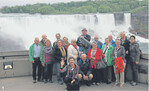 Fröhlich unterwegs: Die Reisegruppe mit Reiseführerin Margareta (winkend) startete an den Niagara-Fällen. Im Hintergrund der amerikanische Teil des Wasserspektakels. Der kanadische, das „Hufeisen", befindet sich rechts und ist hier nicht zu sehen, die Grenze verläuft in Flussmitte