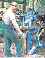 Ein vertikaler Holzspalter mit Zapfwellenantrieb im Arbeitseinsatz.
