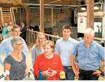 Angela Merkel im Milchviehstall von Familie Trede in Nienborstel.