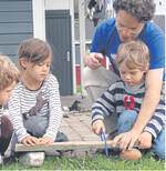 Große Hände zeigen anfangs, wies geht: Man setzt sich hinter das arbeitende Kind, umfasst dessen Hand und führt das Schnitzen oder Sägen mit ihm durch.