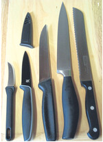 Grundausstattung v. l. n. r.: Schälmesser mit gebogener Klinge, Gemüsemesser, Kochmesser in einfacher Ausführung mit kürzerer Klinge, Kochmesser mit „Kropf" in stabilerer Ausführung mit längerer Klinge, und Brotmesser mit Wellenschliff