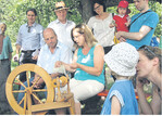 Brigitte Bussmann zeigt Martin Hahn, MdL/ Die Grünen, das Wollespinnen am Spinnrad.