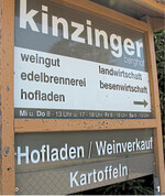 Hinweistafel an der Zufahrtsstraße im Tal auf Angebot und Öffnungszeiten des Berghofs.