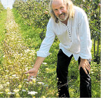 Landwirt Erhard Karrer in seiner Obstanlage mit Blühstreifen.