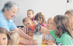 Eine besondere Erfahrung: einmal selber Butter schlagen. Altbäuerin Käthe Leibfried zeigt den Kindern, wie es geht.