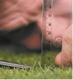 Rasenschnitt mit Schere und Lineal, das charakterisiert überspitzt den Perfektionist.