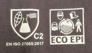 Der Erlenmeyerkolben mit Blatt zeigt an, dass es sich hierbei um Arbeitskleidung handelt, die nach DIN EN ISO 27065 zertifiziert ist.
