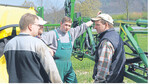 Landwirte im Gespräch vor einer Anhänge-Feldspritze: Nach Einschätzung der Pflanzenschutzindustrie haben Landwirte bis in zwei Jahren weniger Pflanzenschutzmittel zur Verfügung, weil die Behörden mangels Personal den Zulassungsstau nicht auflösen können.