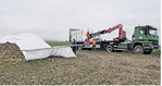Der mechanische Mietenschutz hier durch die LMZ Franken erleichtert die beschwerliche Arbeit. Der Anbauer muss das Vlies noch beschweren, damit es vom Sturm nicht weggeweht werden kann.