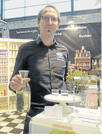 Ausgezeichnet: Tobias Loebke hält in der rechten Hand eine Karaffe mit dem prämierten Kräutersirup aus Cola-Kraut.