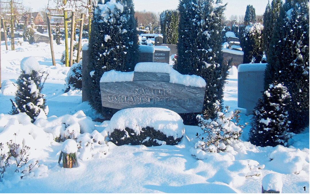Schnee sorgt für eine winterliche Grabdekoration.