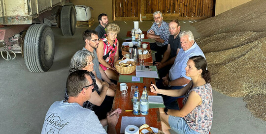 Erntegespräch mit den Brüdern Martin (links) und Andreas Schwörer (3.v.l.) sowie Kreisobmann Karl Endriß (2.v.r), mit Martina Magg-Riedesser (4.v.l.), Erste stellvertretende Vorsitzende, Alexander Keller, stellvertretender Vorsitzender (3.v.r.) und die Landfrauenvorsitzende Doris Härle (2.v.l.). Im Bild hinten rechts ist Seniorchef Johannes Schwörer.