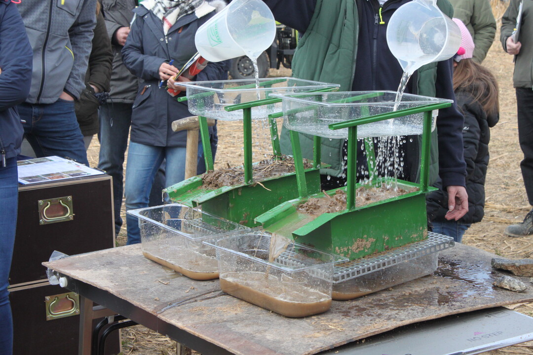 Anhand dieses einfachen Versuches wurde gezeigt, wie wichtig eine Bodenbedeckung ist. Zu sehen ist, dass ohne Bodenbedeckung (rechts) wesentlich mehr Feinpartikel abgeschwemmt werden und weniger Wasser infiltriert.