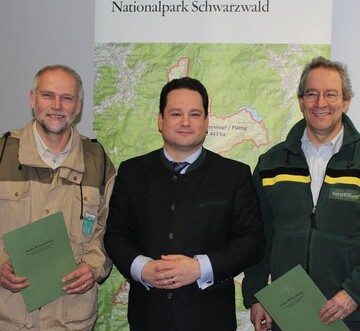 Minister Alexander Bonde bergibt die Ernennungsurkunden an Dr. Wolfgang Schlund (links) und Dr. Thomas Waldenspuhl (rechts) am 19. Dezember 2013 in Stuttgart.