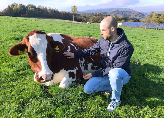 Er kennt die Namen und Eigenheiten aller Kühe des Hofes: Jonas Klein mit einer seiner Lieblingskühe.