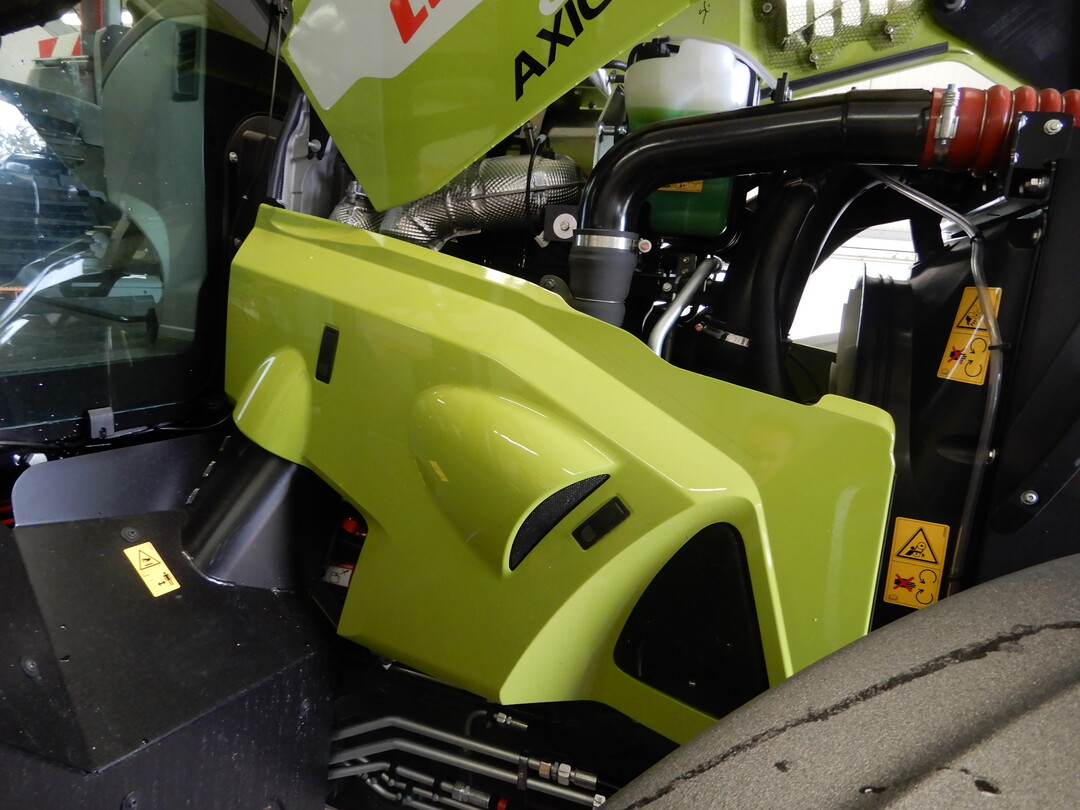 Die seitlichen Motorverkleidungen lassen sich am Claas Axion 830 CMATIC einfach per Schnappverschlsse abnehmen. Der seitliche Zugang an den Schlepper ist durch die schwenkbaren und arretierbaren vorderen Kotflgel prima zugnglich.