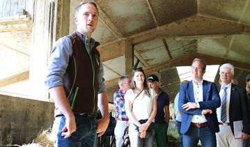 Betriebsleiter Jakob Sigg (links) stellt den Besuchern seine Milchviehhaltung vor. Mit auf dem Bild sind seine Partnerin Verena Mennig sowie die beiden CDU-Abgeordneten Raimund Haser und Klaus Burger (rechts).