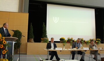 Am Rednerpult und auf dem Podium v. l.: VbwZ-Vorsitzender Joachim Rukwied, Dr. Rainer Schechter von der Sdzucker AG, VSZ-Vorsitzender Dr. Hans-Jrg Gebhard und die neue VbwZ-Geschftsfhrerin Dr. Larissa Kamp.