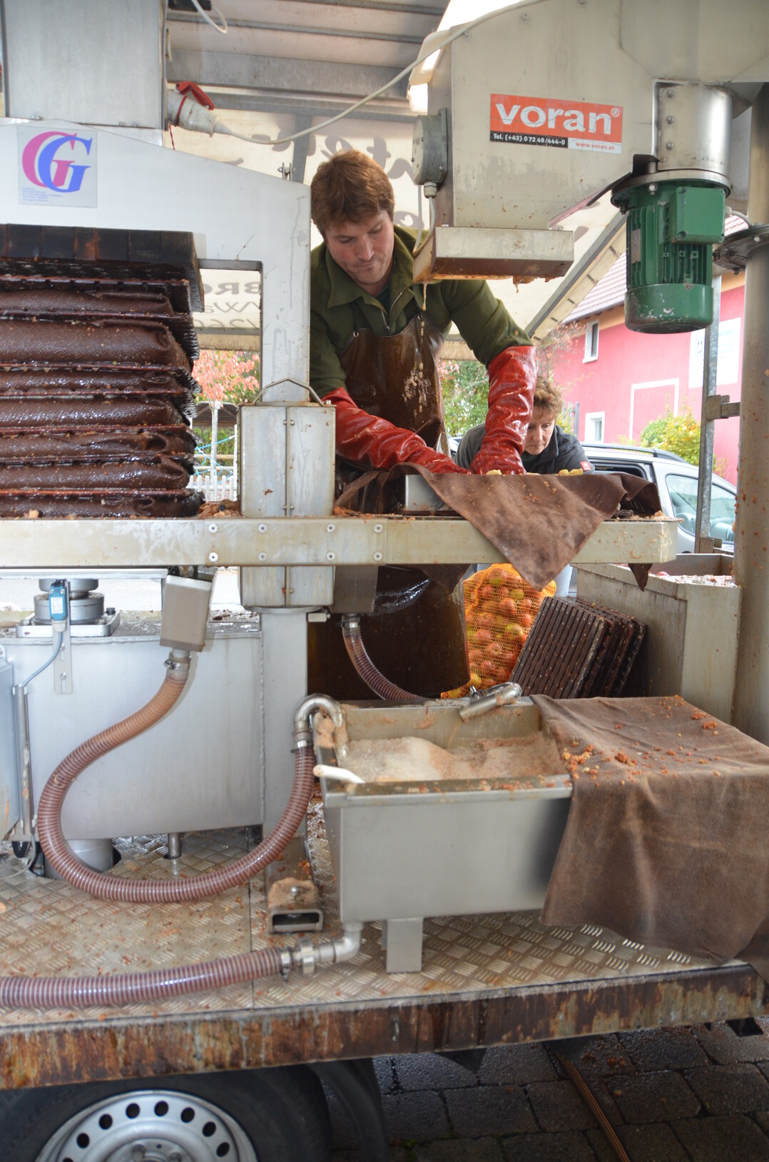 Die Äpfel werden nach dem Waschen geraspelt. Die Masse wird dann in Tücher eingeschlagen. Dabei helfen die Anlieferer selbst mit.