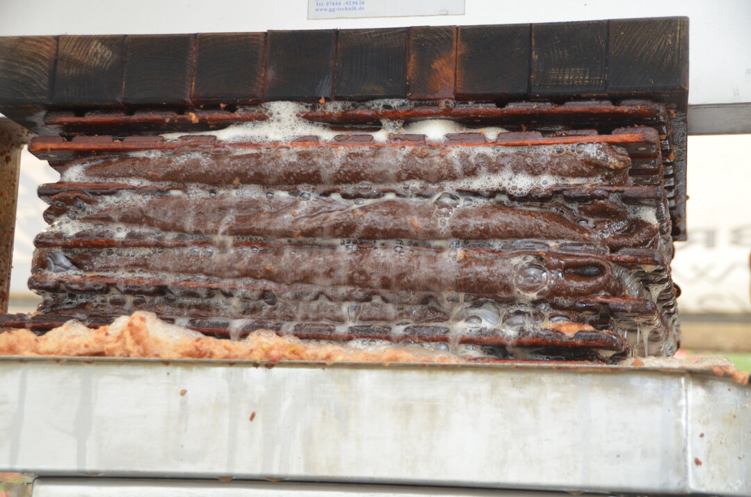 Wenn genug Material unter der Presse liegt, geht es los: Mit ordentlich Druck wird die Flüssigkeit aus den Apfelstücken gepresst.