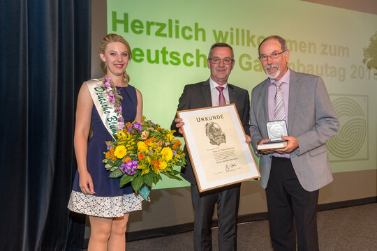 Jrgen Mertz, Prsident des Zentralverband Gartenbau e.V., und die Deutsche Blumenfee 2014/2015, Christina Aumann, gratulieren Dr. Walter Hartmann (re.) zu seiner Ehrung.