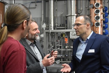 Oliver Reber, Prof. Dr. Ralf Kölling-Paternoga von der Universität Hohenheim und Alexander Plank, Geschäftsführer der Firma Plank,im Gespräch vor der digitalisierten Brennerei.