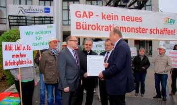 DBV-Prsident Rukwied bergibt Bundeslandwirtschaftsminister Schmidt die Resolution des DBV