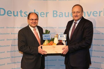 DBV-Prsident Rukwied (rechts) setzt ein Zeichen mit der bergabe einer Kiste mit leckeren Lebensmitteln an den Bundeslandwirtschaftsminister Schmidt: Wir machen satt, wir machen Genuss!