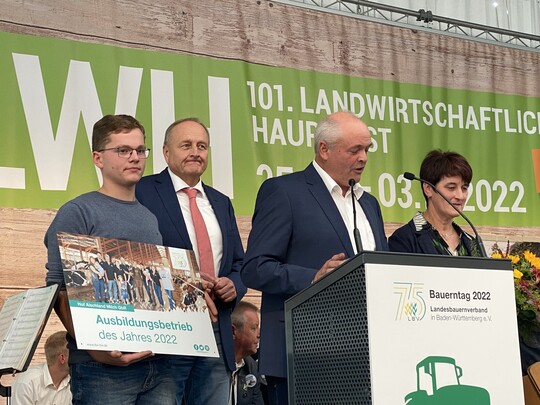 Auszubildender Levi Schmidt (l.) nimmt die Auszeichnung für die Aischland GbR entgegen. Norbert und und Margret Beck freuen sich über den Preis aus der Hand von LBV-Präsident Joachim Rukwied.