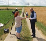 Doppel-Interview: Vorne DBV-Präsident Joachim Rukwied im Gespräch mit einer Videojournalisten, im Hintergrund antwortet Rüdiger Beck auf die Fragen einer Radiojournalistin