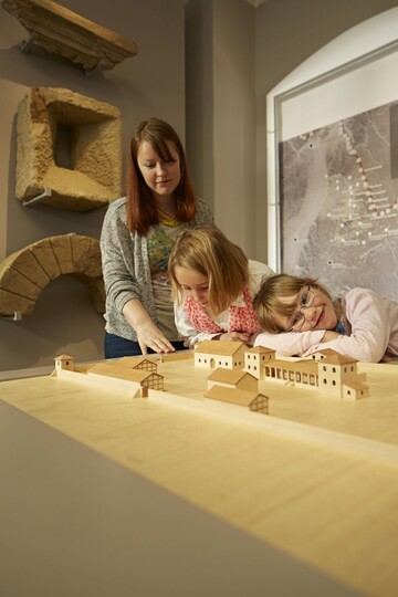 Kinder beim Besuch der Ausstellung "Unter rmischer Herrschaft" mit einem Modell der Villa Rustica.
