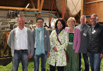 Beim Rundgang auf dem Betrieb Peter ist der Roboter (hinten) ein Publikumsmagnet. Im Bild (v.l.): Johannes und Martha Peter, Petra Krebs (MdL Grüne), Charlotte Fiessinger, Erhard Nonnenmacher und Michael Welte von der Allgäuer Emmentaler Käserei Leupolz eG.