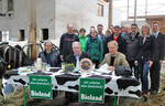 Vertragsunterzeichnung, am Tisch von links: Milchbauer Stefan Zenner, Vorsitzender der MEG Mittelgebirgsbauern, Joachim Kemper, Geschäftsführer der Gläsernen Molkerei, Hubert Böhmann.Dahinter: Die neuen MEG-Vertragspartner. Rechts außen: Sabine Berger, Geschäftsführung Bioland Rheinland-Pfalz/Saarland e.V.