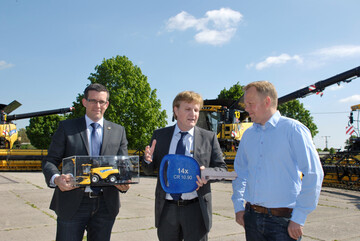 V.l.: Dr. Daniel Fischer, New Holland Produktmanager Mhdreschern, und Vincenzo Cetani, New Holland Geschftsfhrer Deutschland, bergeben den symbolischen Schlssel fr die neue Mhdrescherflotte an Torben Plsch, Chef der deutschen Standorte der Baltic Agrar.