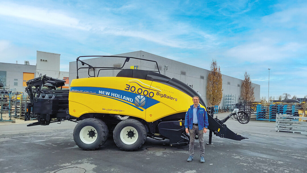 Luigi Neirynck, New Holland Werksleiter in Zedelgem mit der 30.000sten Groballenpresse, die im Erntemaschinen-Kompetenzzentrum in Zedelgem vom Band gelaufen ist. Die 30.000ste Ballenpresse ist mit einem Aufkleber versehen, den New Holland anlsslich dieses Ereignisses entworfen hat.  